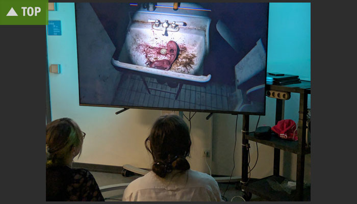 Studenten spielen P.T. auf einer Leinwand